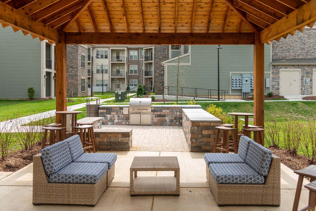 a covered patio with wicker furniture and a fire pit at The Whitworth, Williamsburg, Virginia