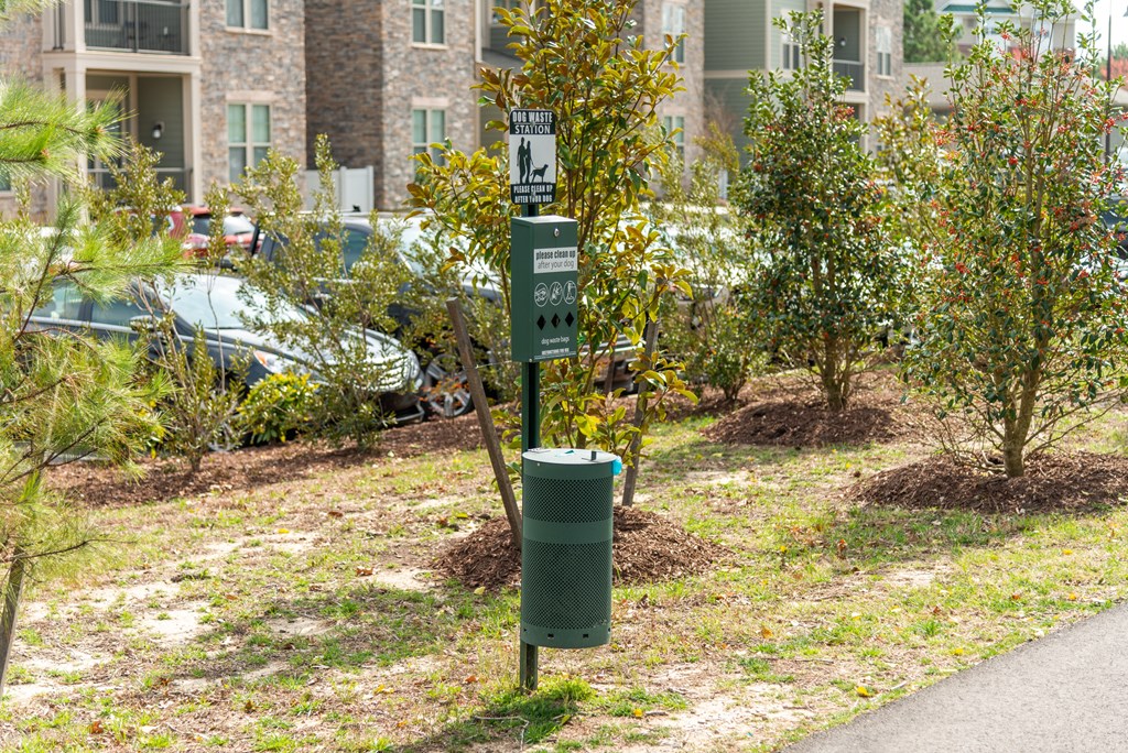 a sign in a park with a trash can next to it at The Whitworth, Williamsburg, VA