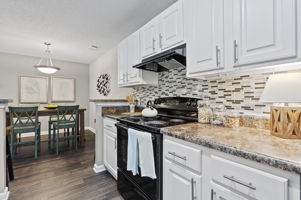 A kitchen with a black stove top oven and white cabinets