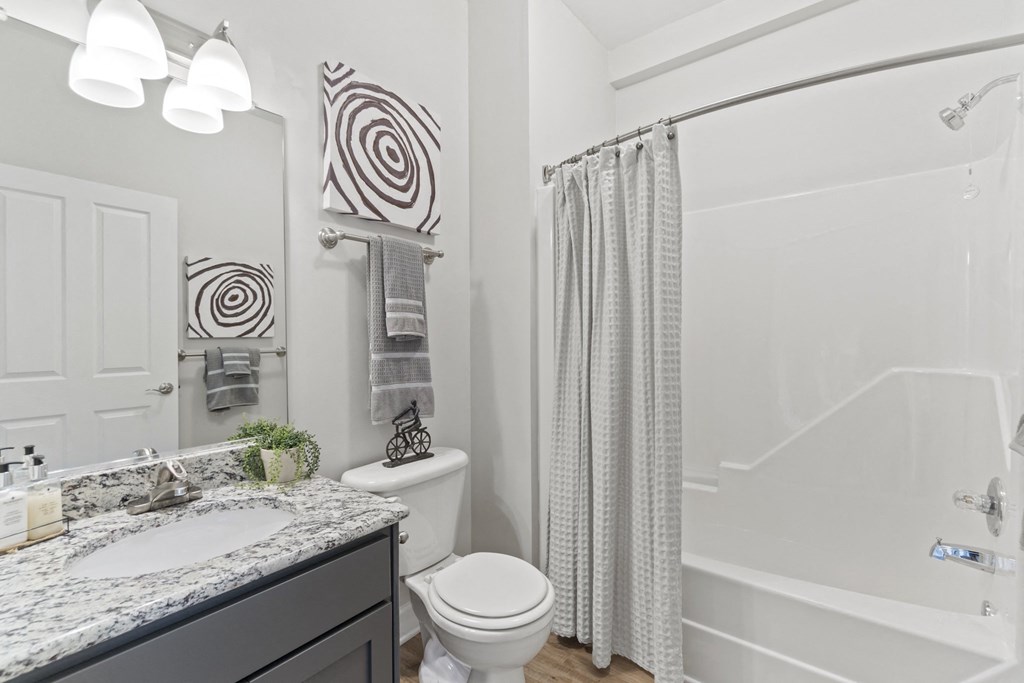A bathroom with a white toilet, a sink, and a shower at Saltmeadow Bay, Virginia Beach, Virginia