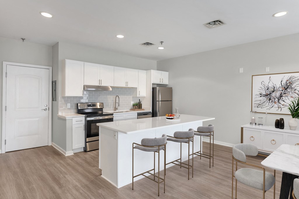 an open kitchen and dining area with a white island and stools
