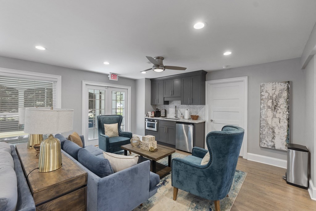 A living room with a blue chair and a grey couch