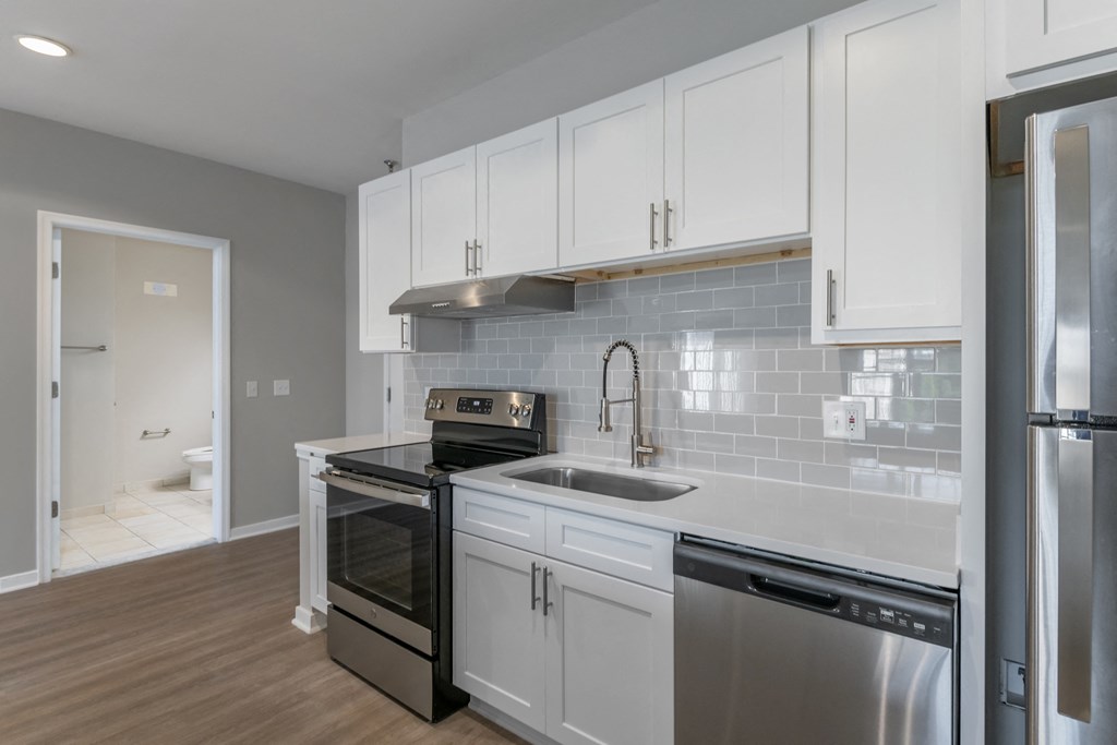 a kitchen with white cabinets and stainless steel appliances and a sink