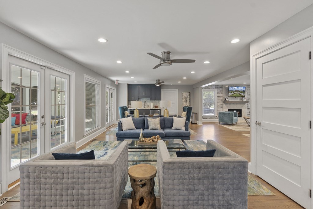 A clubhouse room with a grey sofa set and a ceiling fan