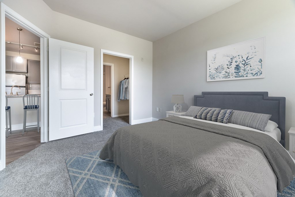 A bedroom with a large bed and a painting on the wall at Streets of Greenbrier, Chesapeake, 23320