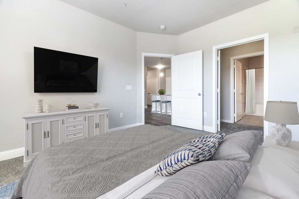 A living room with a grey sofa and a television on the wall at Streets of Greenbrier, Chesapeake, Virginia