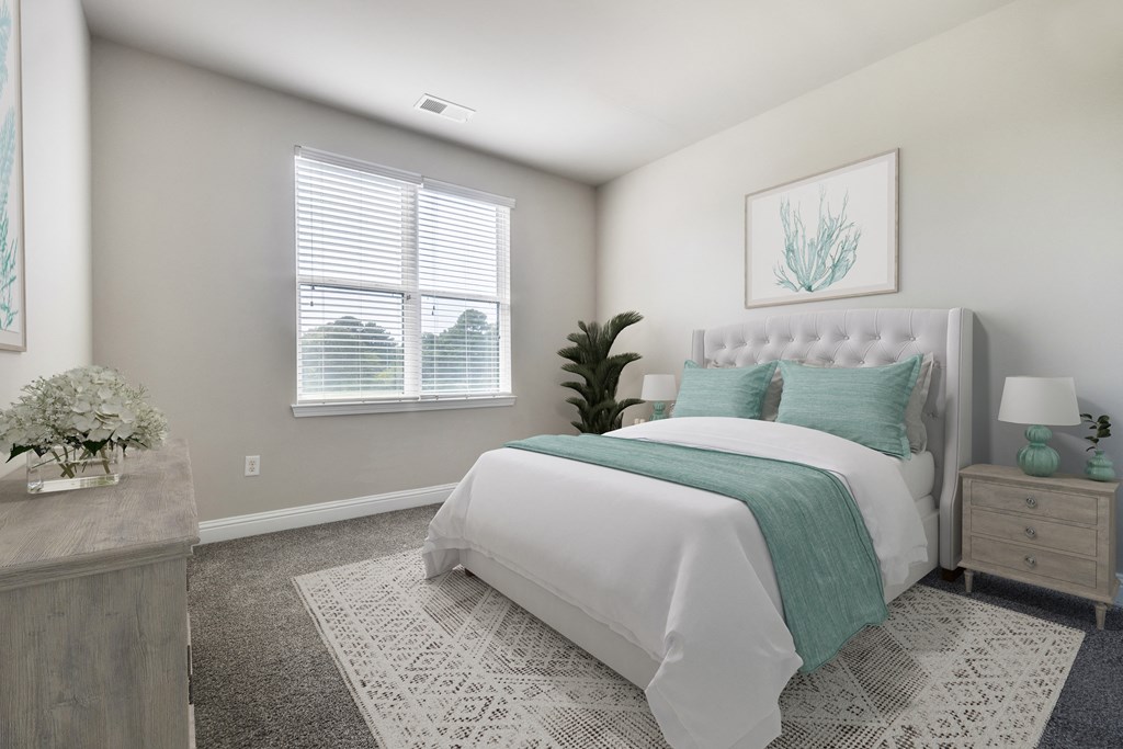 A bedroom with a large bed and a potted plant at Streets of Greenbrier, Chesapeake, VA