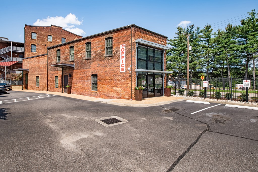 a red brick building with a sign on the side of a street at Mayton Transfer Lofts in Petersburg, Virginia 23803
