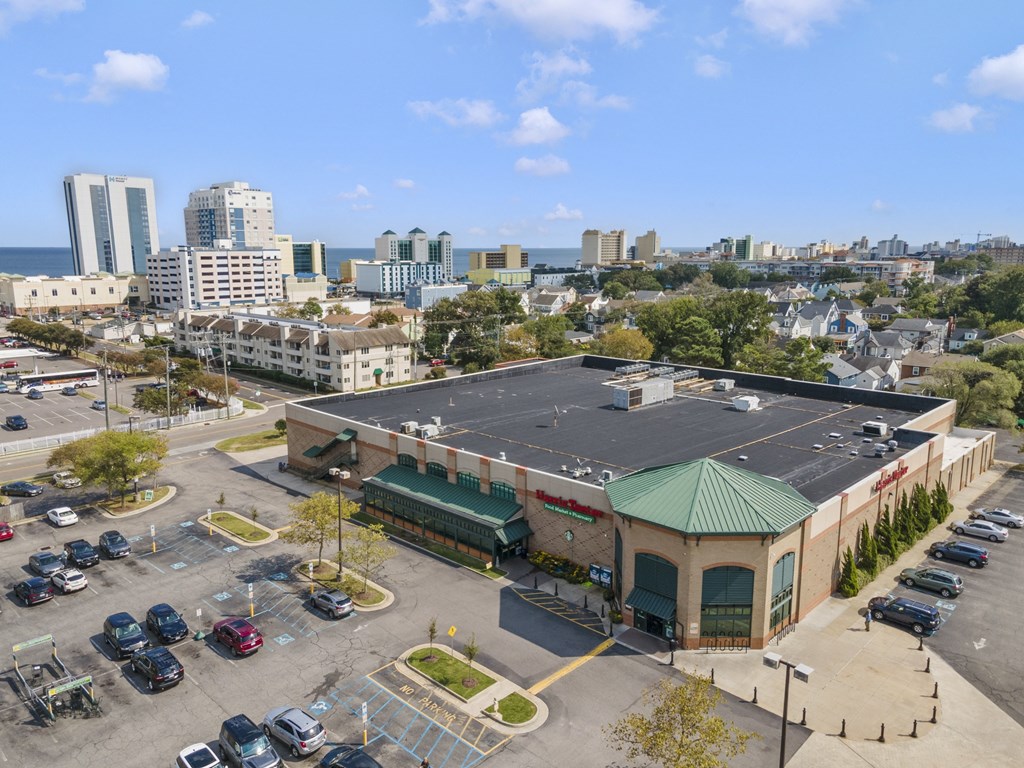 an aerial view of a building with a parking lot and a city in the background at Saltmeadow Bay, Virginia Beach, 23451