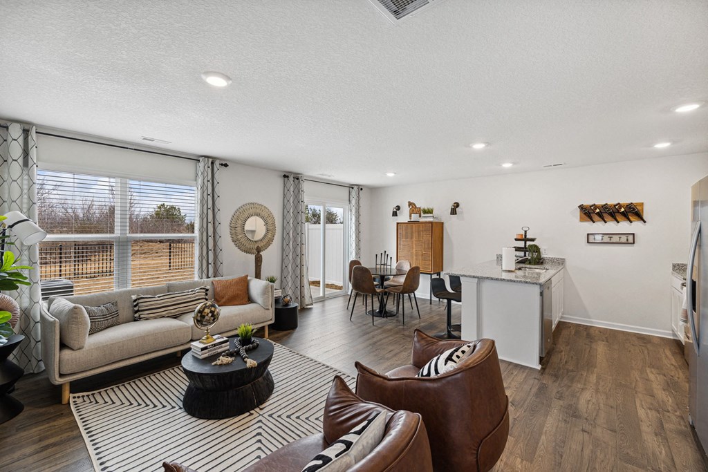 a living room with couches and chairs and a kitchen with a large window at Summit Place Apartments, Oak Ridge, TN
