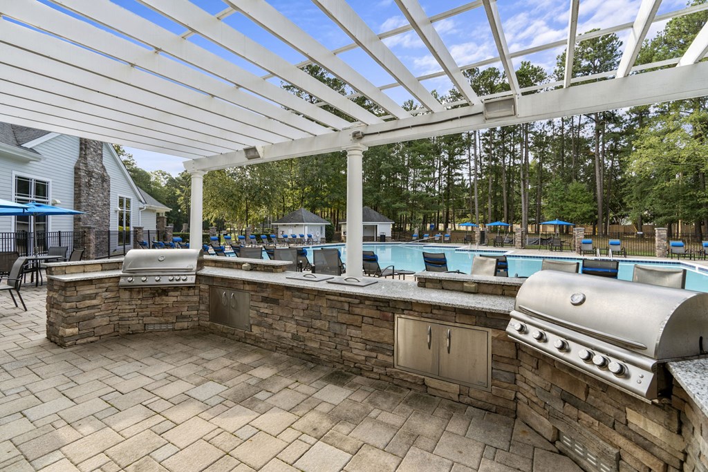 a covered outdoor kitchen with a pool in the background at Trails at Short Pump Apartments, Richmond, VA