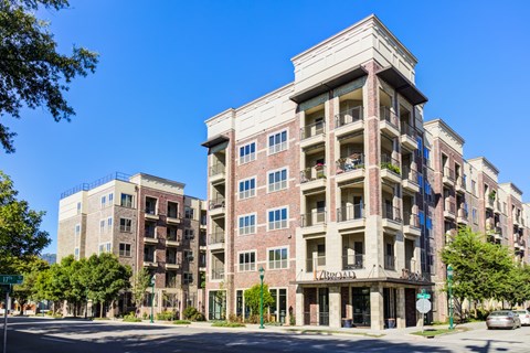 A tall apartment building with a balcony on the second floor.
