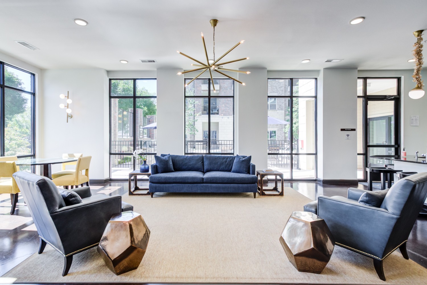 A living room with a blue couch and a large window.