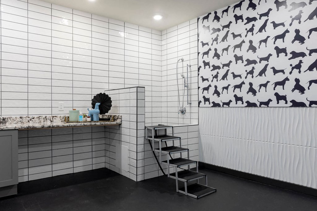 a bathroom with white tiles and a black and white pattern on the wall at Tapestry West, VA 23230