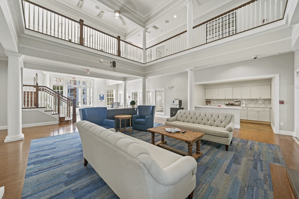 A large, open living room with a staircase and a blue rug  at Sterling Manor, Williamsburg