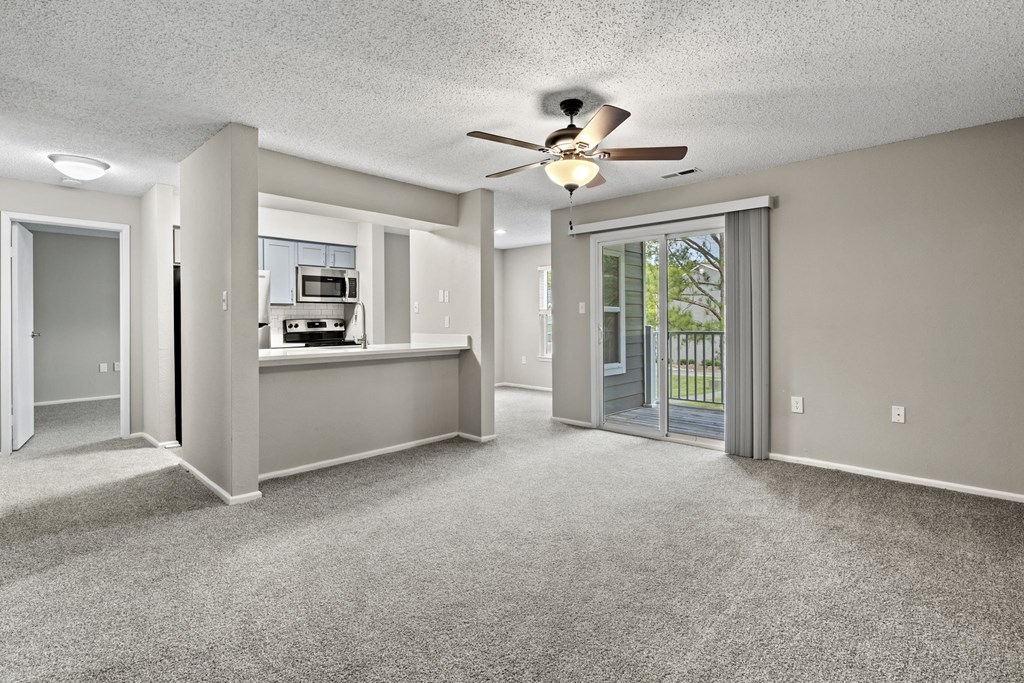 an empty living room with a ceiling fan and a kitchen at Trails at Short Pump Apartments, Richmond, 23233