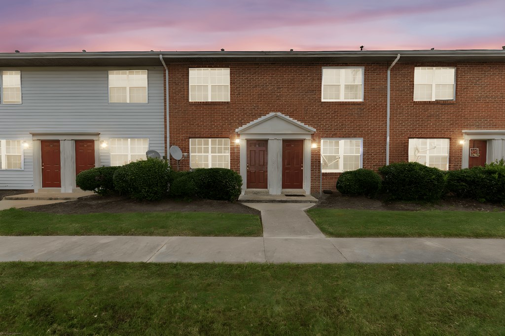 A residential building with a red brick facade and a white garage door.