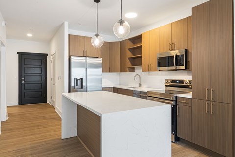 A modern kitchen with wooden cabinets and a white island.