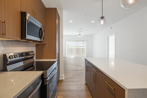 A modern kitchen with dark wood cabinets and stainless steel appliances.