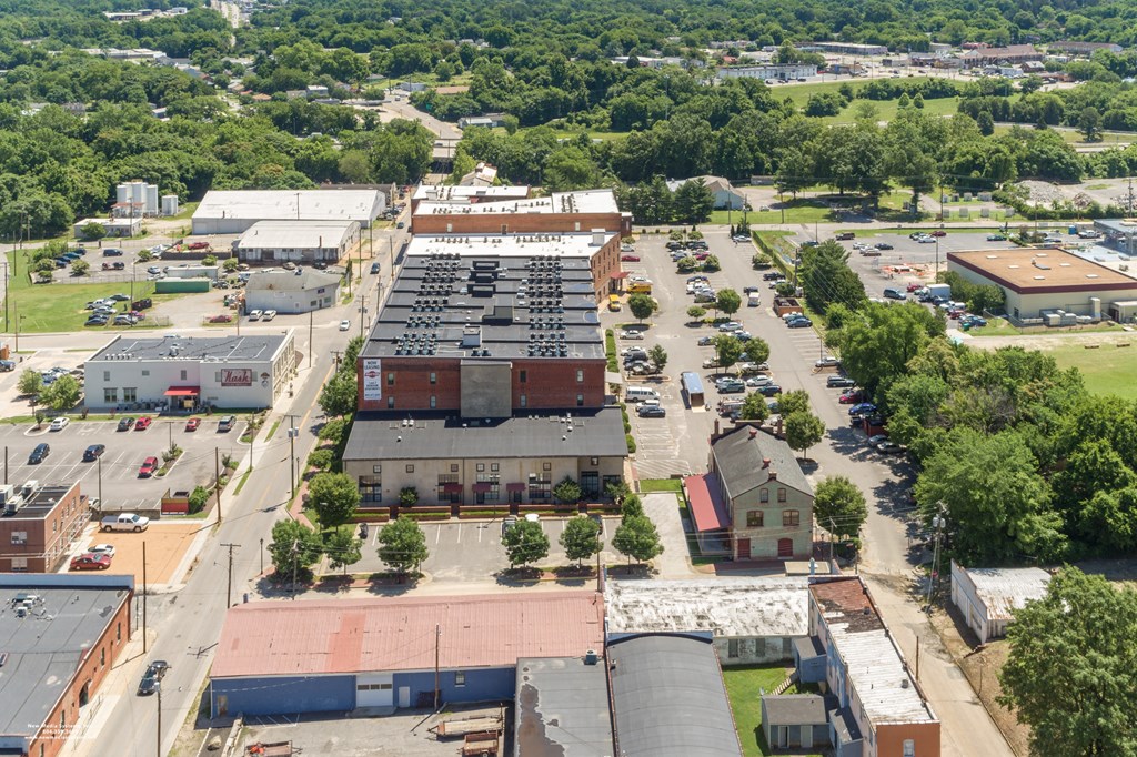an aerial view of the parking lot and rooftops of buildings in a city at Mayton Transfer Lofts in Petersburg, 23803