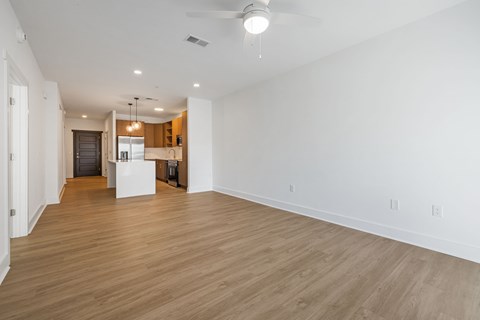 A spacious room with wooden flooring and a ceiling fan.