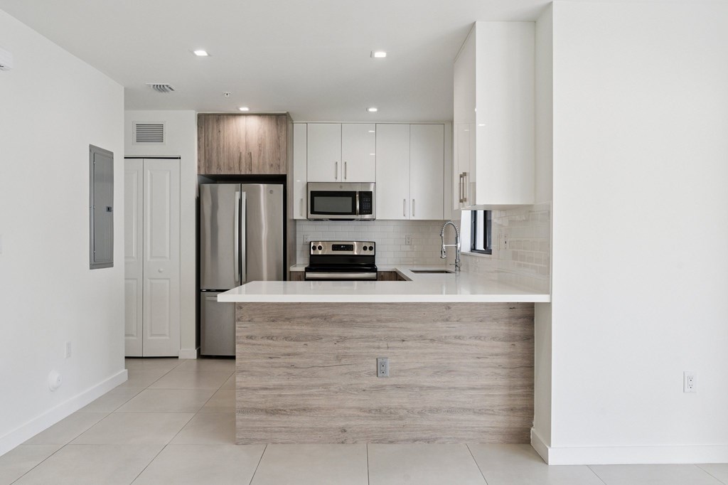 A modern kitchen with a wooden island in the middle.at The Villages at Miami Gardens, Florida, 33056