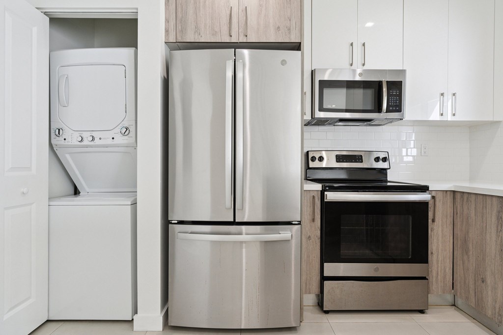 A modern kitchen with a stainless steel refrigerator, oven, and microwave.at The Villages at Miami Gardens, Miami Gardens, FL