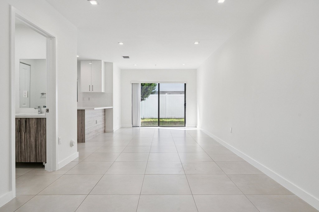 A spacious, empty room with white walls and tile flooring.at The Villages at Miami Gardens, Miami Gardens Florida