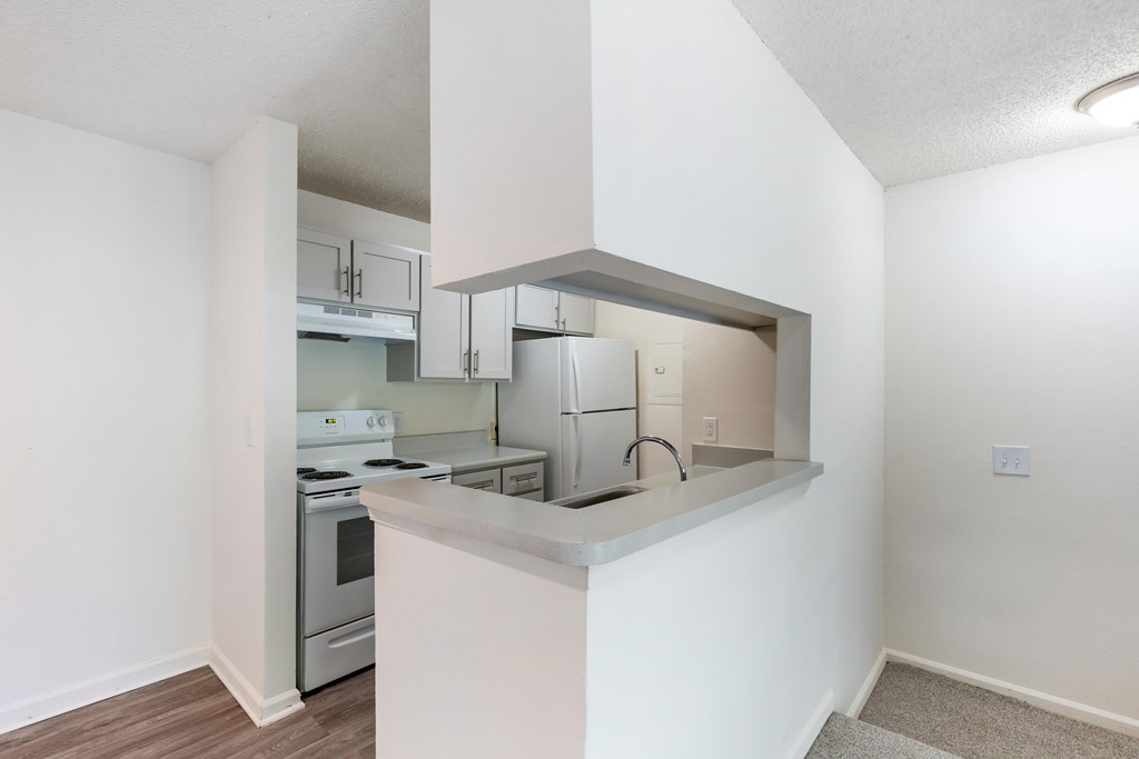 A kitchen with white walls and a stove top oven.