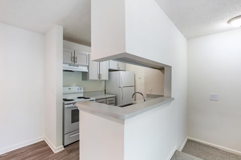 A kitchen with white walls and a stove top oven.