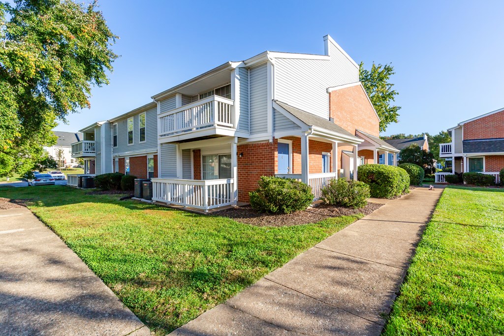 A two-story house with a white porch and a red brick exterior.