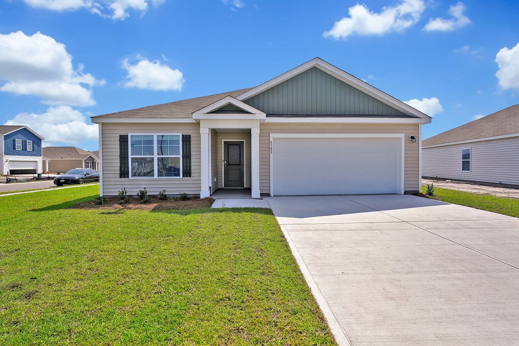 A house with a garage door and a driveway. at Seaboard at Sidbury Station, Castle Hayne