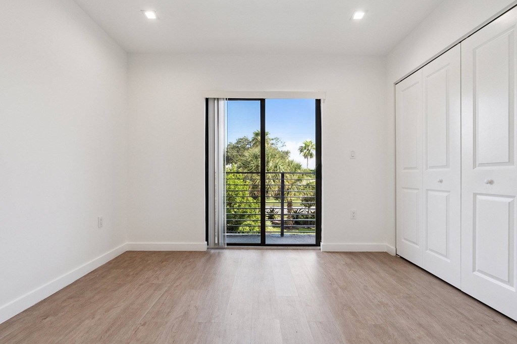A room with a sliding glass door leading to a backyard.at The Villages at Miami Gardens, Miami Gardens, FL