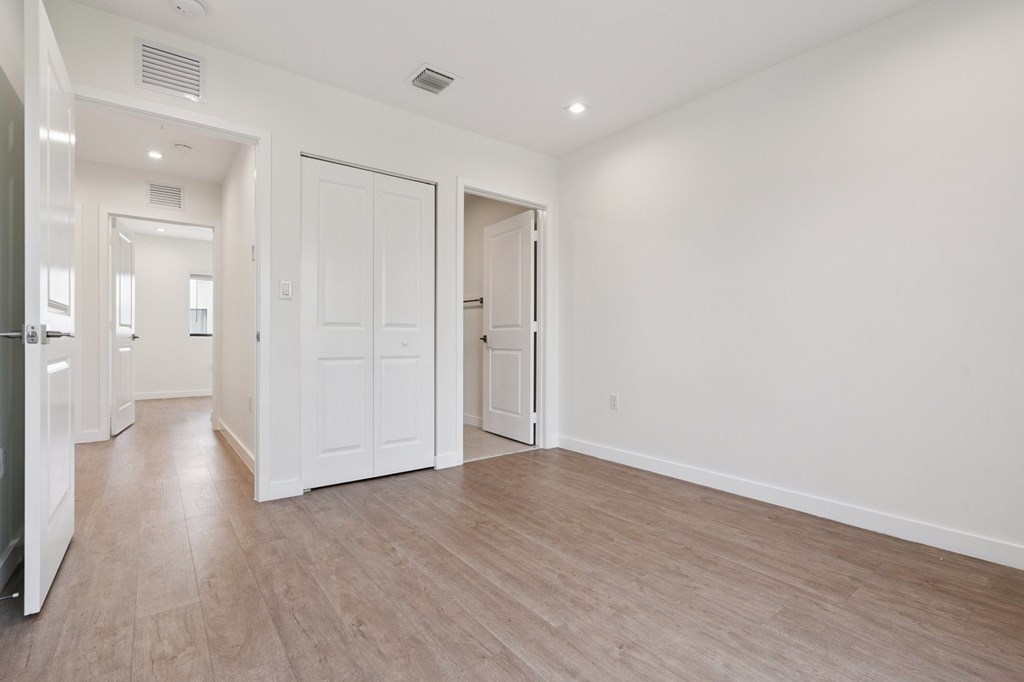 A large empty room with wooden flooring and white walls.at The Villages at Miami Gardens, Florida, 33056