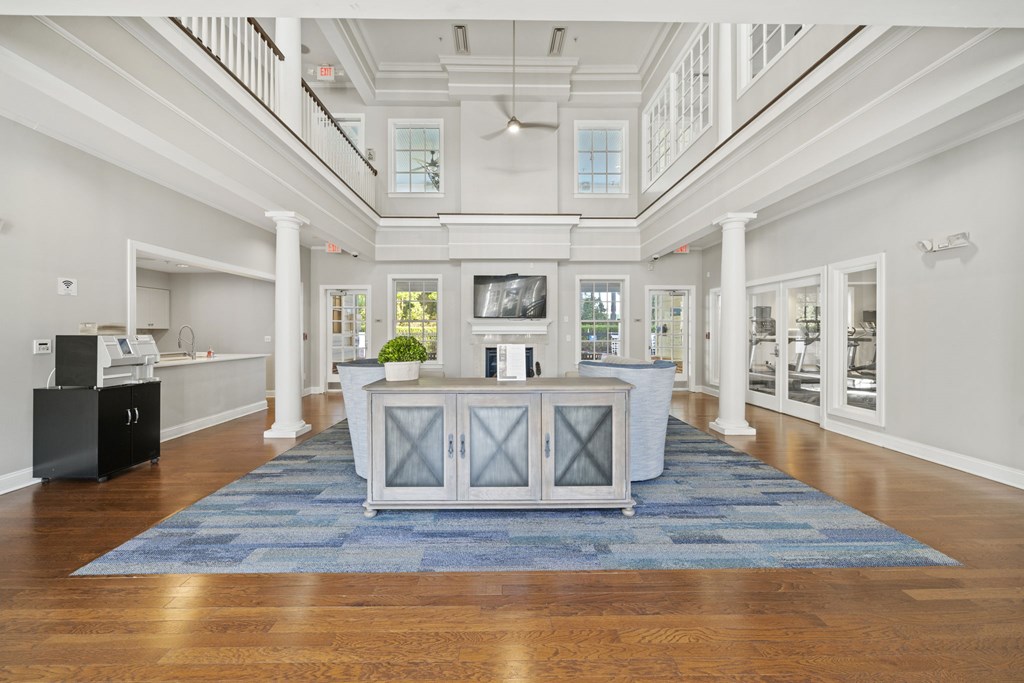 A spacious white hallway with a blue rug and a black cabinet  at Sterling Manor, VA, 23185