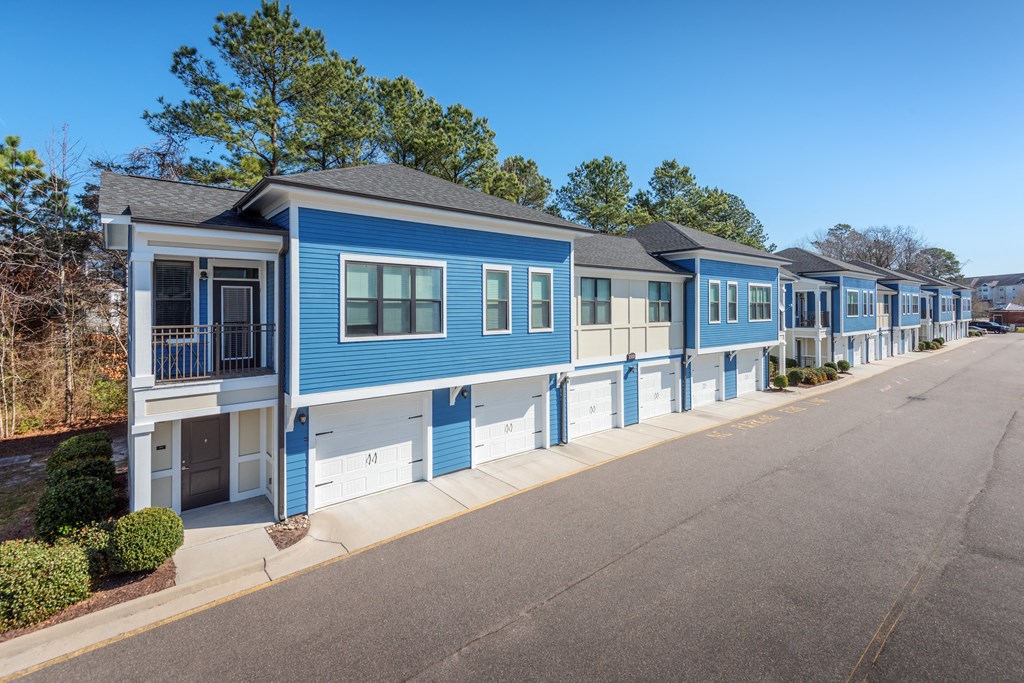 A blue and white mobile home with a porch and a garage door at Streets of Greenbrier, Chesapeake, VA, 23320