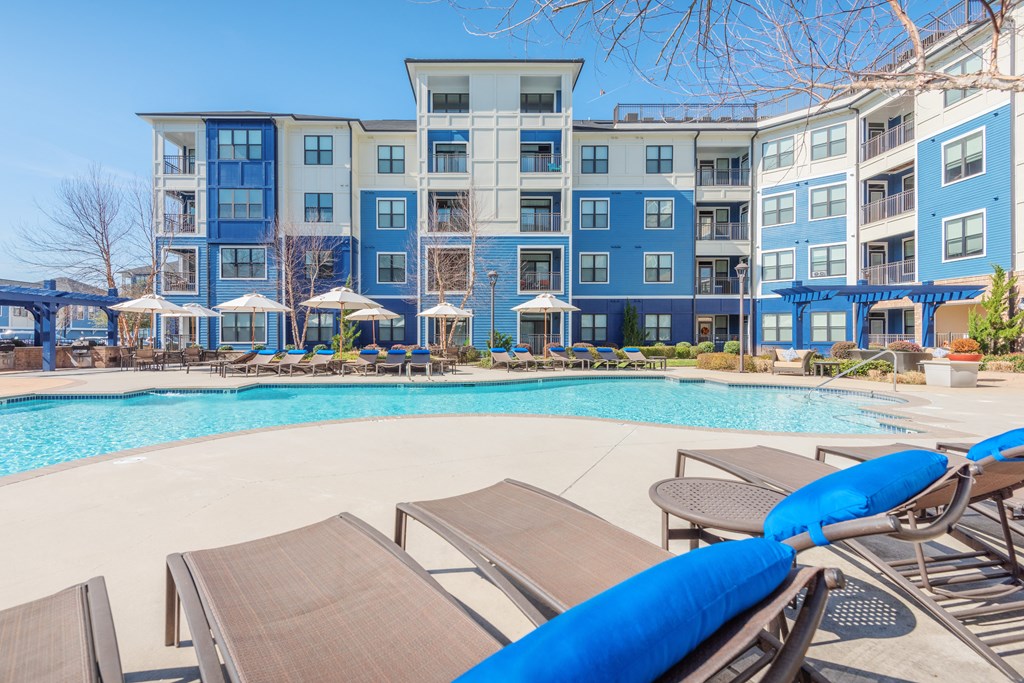 A pool with sun loungers and a building in the background at Streets of Greenbrier, Chesapeake, 23320