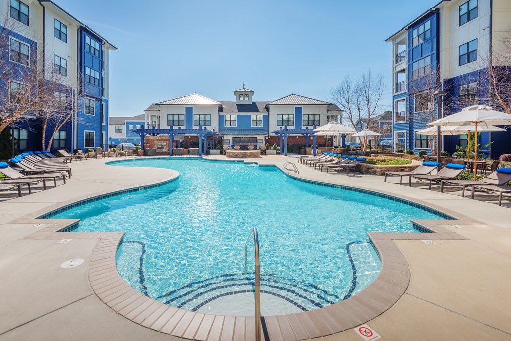 A large swimming pool surrounded by a building and trees at Streets of Greenbrier, Chesapeake, VA