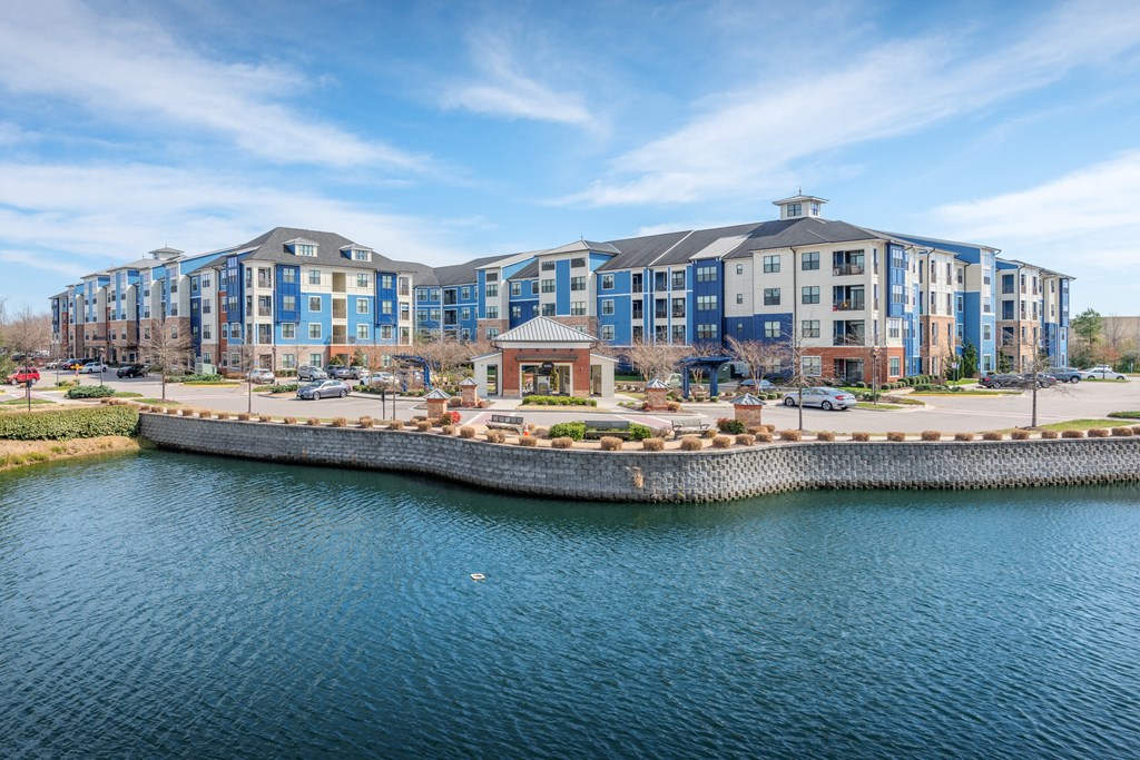 A large building complex sits on the edge of a body of water at Streets of Greenbrier, Chesapeake, VA, 23320
