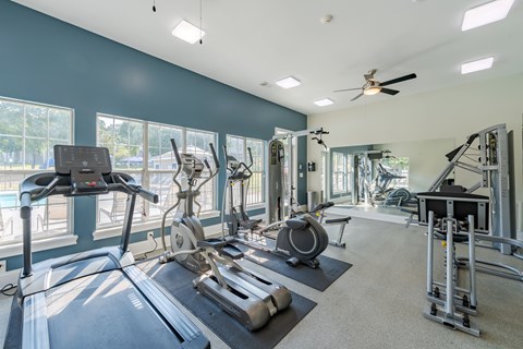 A spacious gym with treadmills, elliptical machines, and other exercise equipment.