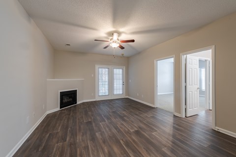 A room with a fireplace and wood flooring.