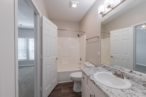A bathroom with a sink, toilet, and bathtub.