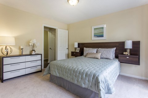 a bedroom with a bed and dressers and a closet a bedroom with a bed and dressers and a closet at Abbington Place Apartments, Greensboro , North Carolina