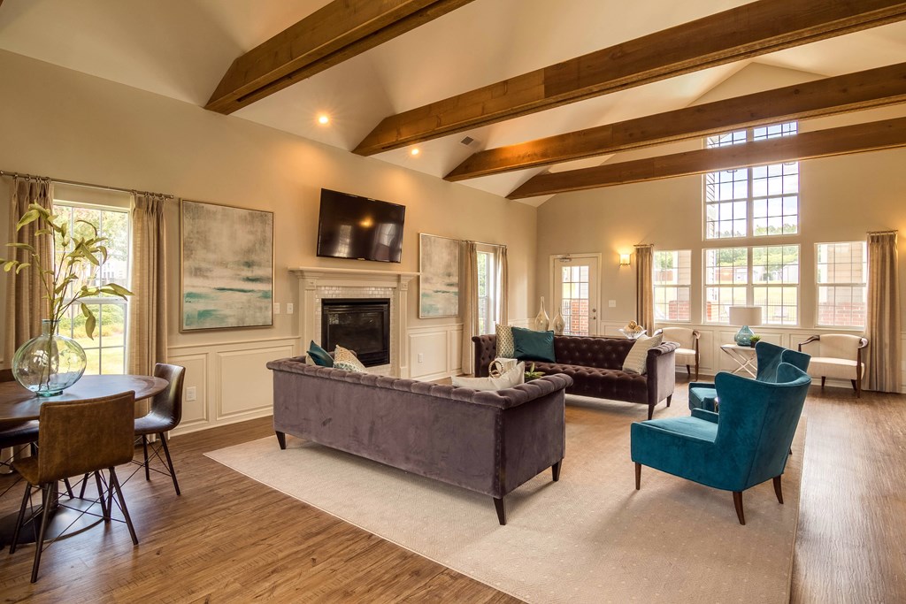 a living room with couches and chairs and a fireplace at Abbington Place Apartments, Greensboro