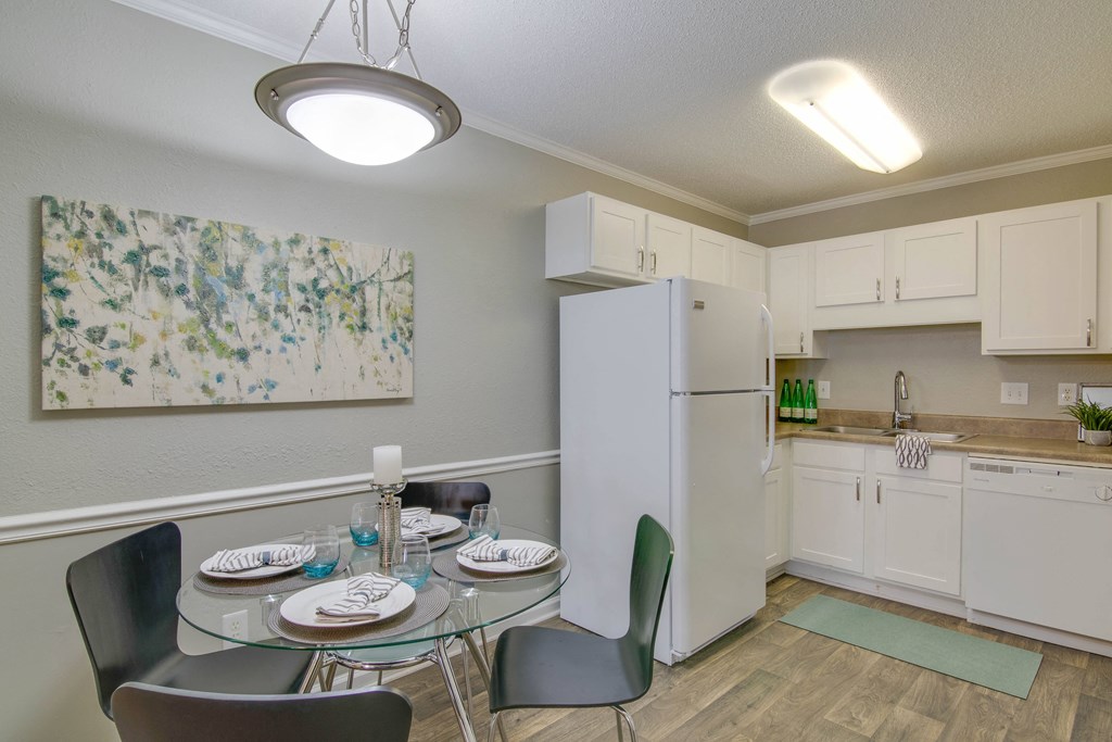 a kitchen and dining room with a table and chairs and a refrigerator at Abbington Place Apartments, North Carolina