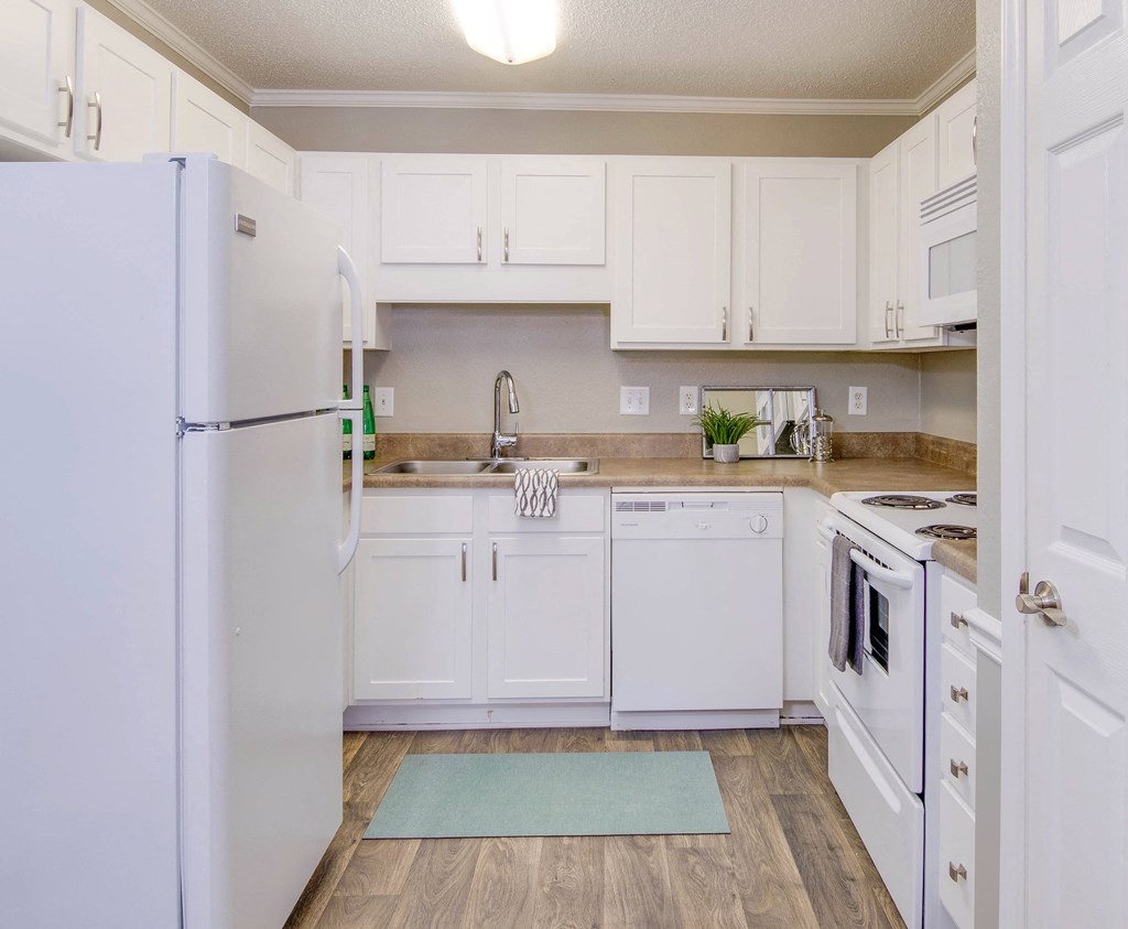 a kitchen with white cabinets and appliances and a refrigerator at Abbington Place Apartments, North Carolina