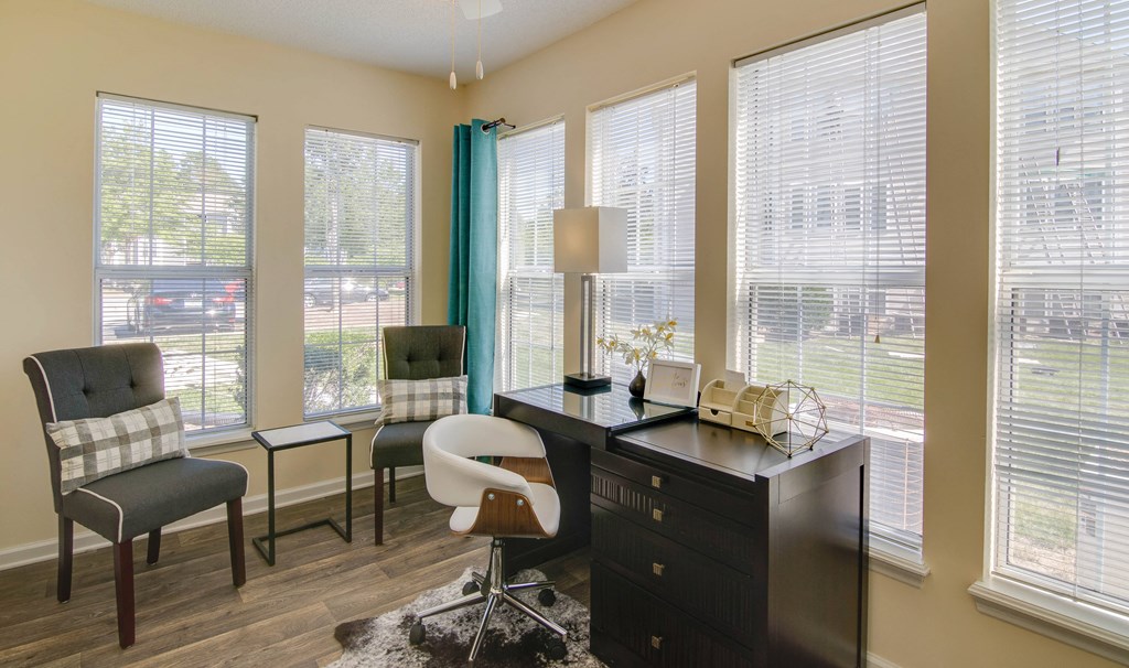 a home office with a desk and chairs and large windows at Abbington Place Apartments, Greensboro , NC 27407