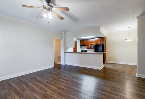 A room with a ceiling fan and wooden flooring.