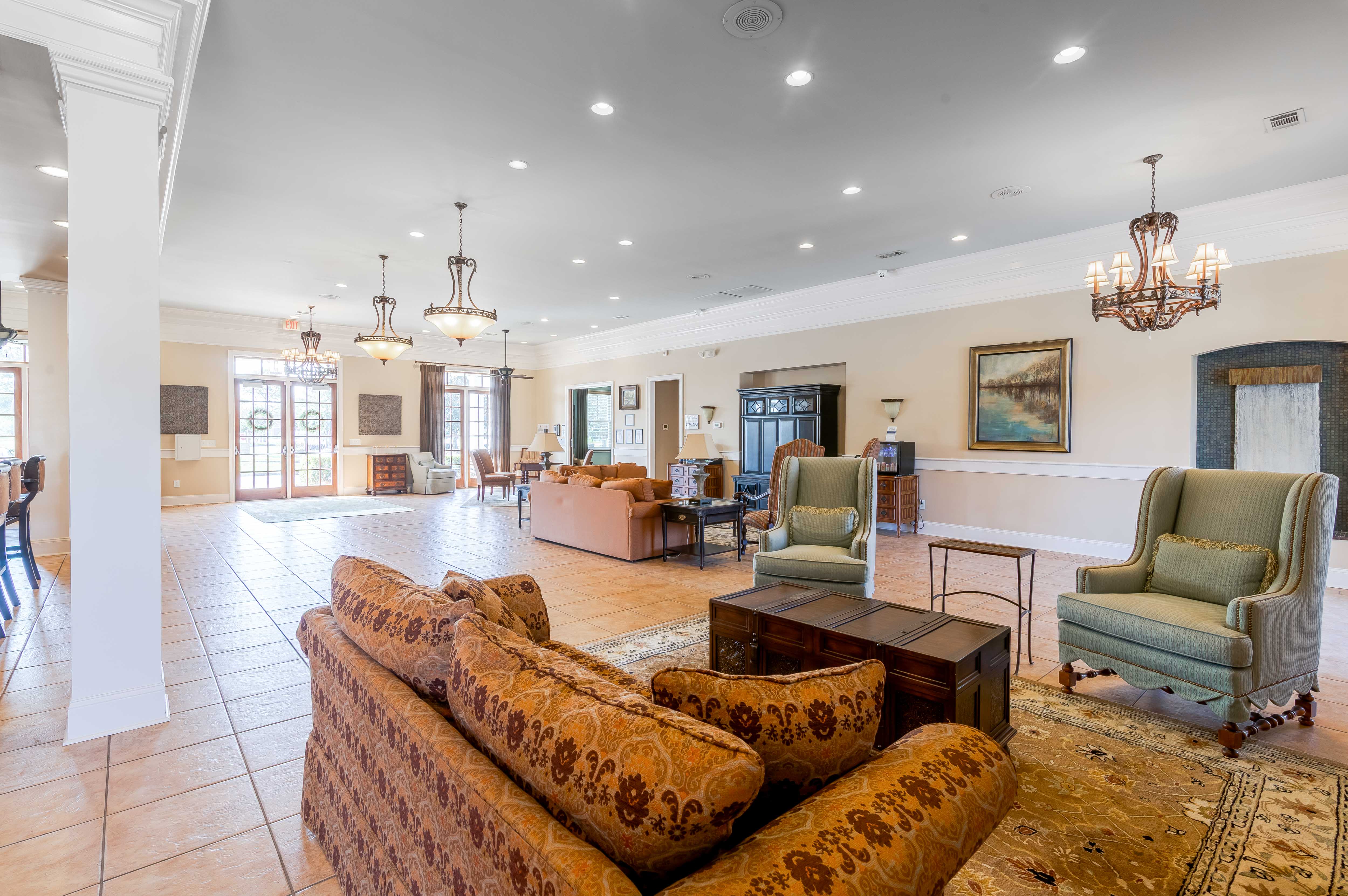 A large, well-lit living room with a sofa set and chairs.