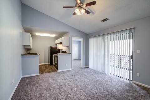 A room with a ceiling fan and carpeted floor.